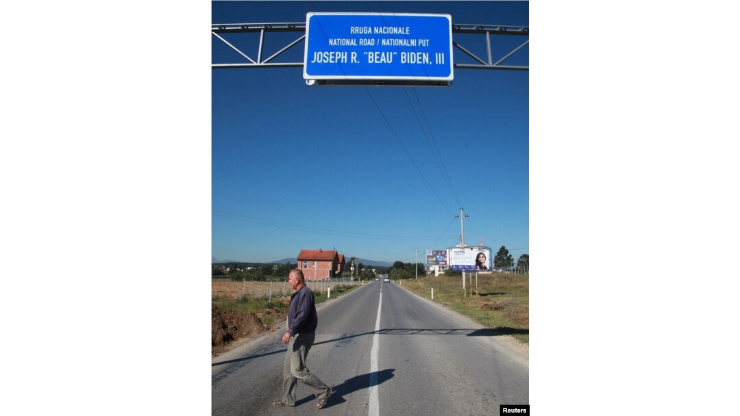 A Kosovar crosses the road ahead of U.S. Vice President Joe Biden's visit, in the village of Sojeve, Aug. 15, 2016.
