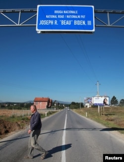 A Kosovar crosses the road ahead of U.S. Vice President Joe Biden's visit, in the village of Sojeve, Aug. 15, 2016.