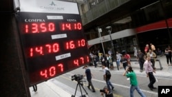 An electronic board shows the exchange rate of several currencies in relation to Argentina's peso, outside an exchange bureau in Buenos Aires, Argentina, Dec. 17, 2015.
