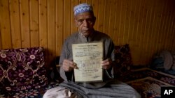 Ghulam Mohammad Zargar, an elderly Kashmiri man shows his domicile document locally know as "State Subject" which was only held by permanent residents of Jammu and Kashmir in Srinagar, Indian controlled Kashmir, Oct. 31, 2019.