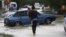 A local resident walks with her child through a flooded street in the southern Russian town of Krymsk July 7, 2012.