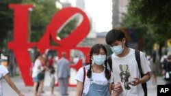 Pengunjung mengenakan masker saat berjalan-jalan di sebuah tempat wisata di Taipei, Taiwan, di tengah pandemi, 30 Mei 2020. (Foto: dok).