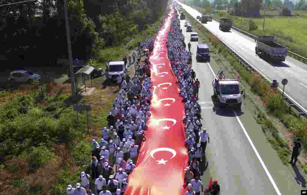 터키 야당인 공화인민당의 케말 클르치다르올루 대표를 따르는 시민들이 1천100m 길이 국기를 펴들고 행진하고 있다. 공화인민당 대표와 지지자들은 야당 정치인 구속에 도보 항의하는 425km &#39;정의의 행진&#39;을 17일째 진행중이다.