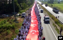 Thousands of supporters hold a 1.100 meter-long national flag as they follow Kemal Kilicdaroglu, on the 17th day of his 425-kilometer (265-mile) march in Sakarya.