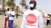 People with a white paper covering their mouth and a t-shirt reading "enough is enough" demonstrate in Dakar on April 22, 2016, against the alleged human rights violations in Gambia.