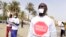 FILE - People with a white paper covering their mouth and a t-shirt reading "enough is enough" demonstrate in Dakar on April 22, 2016, against the alleged human rights violations in Gambia.