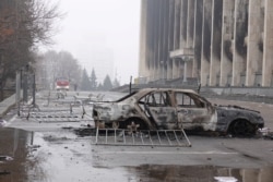 A burnt-out car is seen following anti-goverment protests, outside the city administration headquarters in Almaty, Kazakhstan, Jan. 7, 2022.