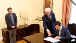 2015年7月6日雅典总统府： 希腊总理齐普拉斯(右)签署协议。左边为希腊新任财长查卡洛托斯