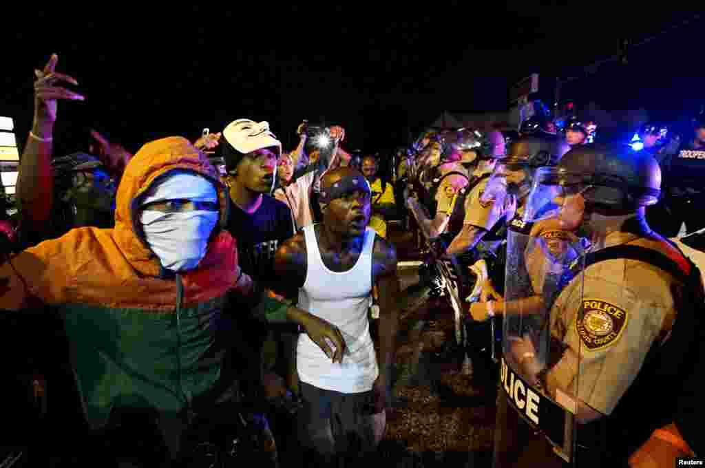 Manifestantes em confronto com a polícia antes de tiroteio em Ferguson, Missouri, 9 de Agosto, 2015.