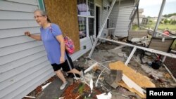 Cathy McCabe camina entre los restos de su casa dañada después de que un tornado generado por el huracán Dorian arrasó Carolina Shores, Carolina del Norte.