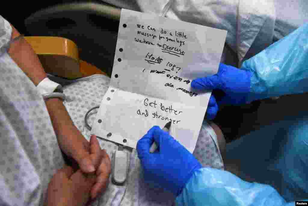 A healthcare worker communicates with a patient who is asking to go home inside the coronavirus disease (COVID-19) unit at United Memorial Medical Center in Houston, Texas, Dec. 28, 2020. 