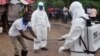 FILE - Health workers wash their hands after taking a blood specimen from a child to test for the Ebola virus in an area where a 17-year old boy died from the virus on the outskirts of Monrovia, Liberia, June 30, 2015. 