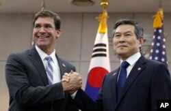 U.S. Defense Secretary Mark Esper, left, and South Korean Defense Minister Jeong Kyeong-doo hold their hands ahead of a meeting at Defense Ministry in Seoul, South Korea, Aug. 9, 2019.
