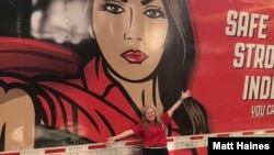 Kellylynn McLaughlin stands in front of the Women in Trucking's Drive Ambassador Trailer, named WITney.