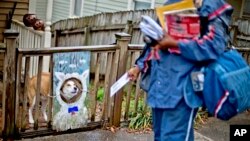 USPS carrier Jamesa Euler encounters barking dog in the Cabbagetown neighborhood of Atlanta, Ga., Feb. 7, 2013.