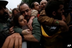 Pro-referendum supporters embrace each other as Spanish National Police tries to remove them from the Ramon Llull school assigned to be a polling station by the Catalan government in Barcelona, Spain, early Oct. 1 2017.