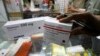 Seorang pemilik apotek memeriksa paket obat yang baru tiba di sebuah pasar di Jakarta. Menteri Koordinator Maritim dan Investasi, Luhut Binsar Pandjaitan mendorong adanya reformasi sistem kesehatan Indonesia. (Foto: REUTERS/Crack Palinggi)