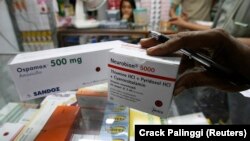 Seorang pemilik apotek memeriksa paket obat yang baru tiba di sebuah pasar di Jakarta. Menteri Koordinator Maritim dan Investasi, Luhut Binsar Pandjaitan mendorong adanya reformasi sistem kesehatan Indonesia. (Foto: REUTERS/Crack Palinggi)