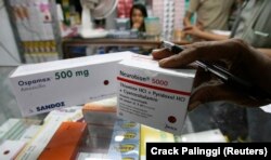 Seorang pemilik apotek memeriksa paket obat yang baru tiba di sebuah pasar di Jakarta, 26 November 2008. (Foto: REUTERS/Crack Palinggi)
