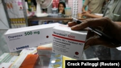 Seorang pemilik apotek memeriksa paket obat yang baru tiba di sebuah pasar di Jakarta, 26 November 2008. (Foto: REUTERS/Crack Palinggi)