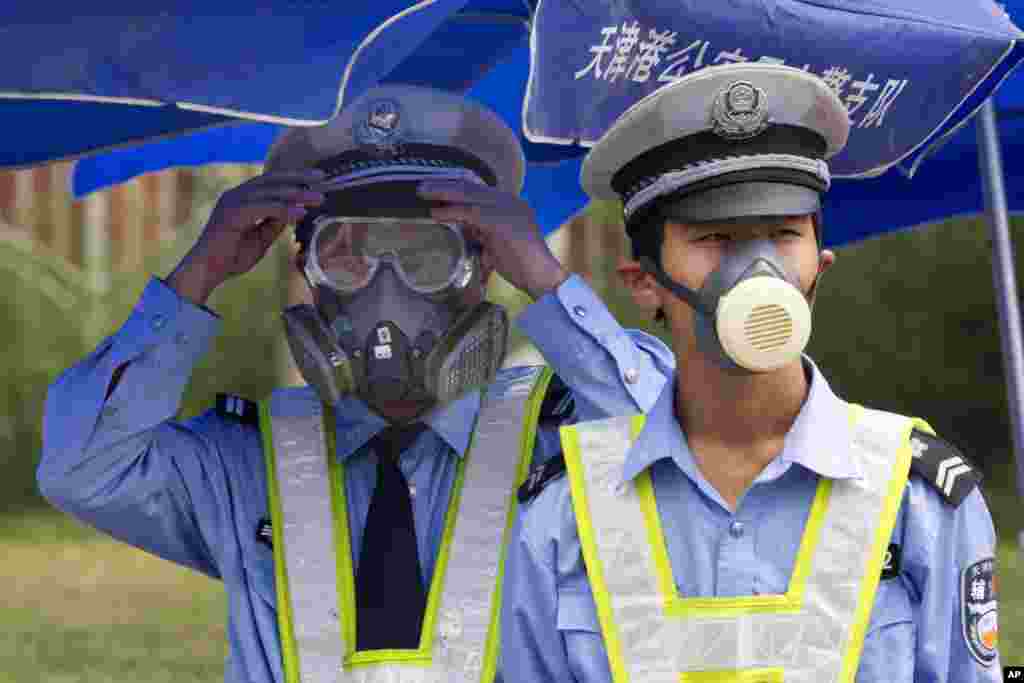 Cảnh sát Trung Quốc đeo khẩu trang canh gác tại một chốt kiểm soát an ninh gần địa điểm&nbsp;vụ nổ ở Thiên Tân, ngày 15/8/2015.