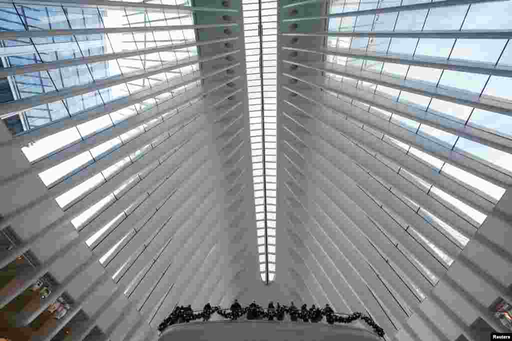 People look out over a balcony at the Oculus Transit Hub in the Manhattan borough of New York City, New York, U.S..