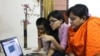 A young school girl in Dhaka, Bangladesh, is teaching her mother how to use Facebook. (S. M. Ashfaque for VOA)