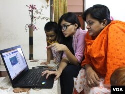 Seorang anak menunjukkan cara menggunakan Facebook kepada ibunya di Dhaka, Bangladesh. (Foto: S.M. Ashfaque/VOA)