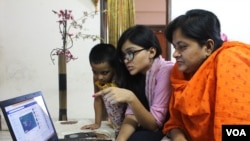 A young school girl in Dhaka, Bangladesh, is teaching her mother how to use Facebook. (S. M. Ashfaque for VOA)
