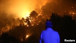 Čovek posmatra požar u selu Mravince u blizini Splita, Hrvatska, 17. jula 2017. (REUTERS/Antonio Bronic)