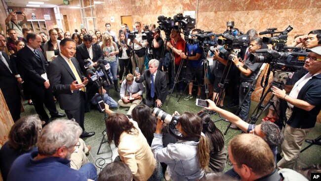 FILE - San Francisco Public Defender Jeff Adachi, left, talks to members of the media after Francisco Sanchez' arraignment in San Francisco, July 7, 2015. Adachi died in February.
