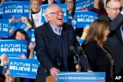 Democratic presidential candidate Sen. Bernie Sanders of Vermont laughs as he arrives with his wife, Jane Sanders, and his son Levi Sanders to a primary night rally in Essex Junction, Vt., March 1, 2016.