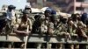 Members of the military gesture to the photographer as they patrol the streets of the capital Harare, Zimbabwe, Aug. 2, 2018. 