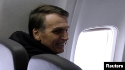 Brazilian presidential candidate Jair Bolsonaro sits on a plane in Sao Paulo, Sept. 29, 2018. 