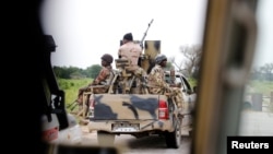FILE - A Nigerian army convoy vehicle with an anti-aircraft gun drives toward Bama, Borno State, Nigeria, August 31, 2016. 