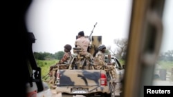 FILE - A Nigerian army convoy vehicle with an anti-aircraft gun drives toward Bama, Borno State, Nigeria, August 31, 2016. 