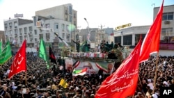In this photo provided by ISNA, flag draped coffins of Gen. Qassem Soleimani and his comrades who were killed in Iraq, are carried on a truck surrounded by mourners during their funeral in Ahvaz, Iran, Jan. 5, 2020. 