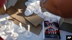 Una biblia y velas colocadas por voluntarios durante una vigilia por las víctimas del tiroteo en la escuela secundaria Marjory Stoneman Douglas, el jueves 15 de febrero de 2018.