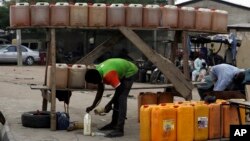 A man sells fuel on the road side in Kano, Nigeria, April 1, 2016. Nigeria has been facing a fuel shortage that has created long lines at gas stations and left travelers stranded on highways.