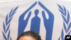 US-American actress Angelina Jolie displays her UN passport in front of the UNHCR logo during a ceremony at the United Nations High Commissioner for Refugees, UNHCR, headquarters in Geneva, Switzerland, (AP Photo/KEYSTONE/Laurent Gillieron)