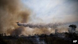 Pesawat tempur melintasi kebakaran yang disebabkan oleh balon yang diikat kain terbakar oleh warga Palestina dari Jalur Gaza di Karmia dekat perbatasan Israel dan Gaza, Kamis, 11 Oktober 2018. 