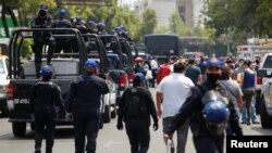 Police officers in Mexico City, Mexico, arrive to control the crowded La Viga fish market during the COVID-19 outbreak April 9, 2020.