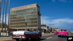 Turistas viajan en autos convertibles clásicos en el malecón junto a la embajada de Estados Unidos en La Habana, Cuba, el 3 de octubre de 2017. 