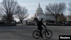 资料照：一名骑车人路过华盛顿的国会大厦。（2023年2月7日）