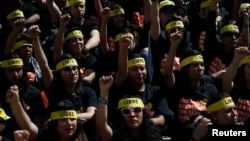 People protesting against human trafficking and slavery raise their fists during a demonstration in Mexico City, Oct. 14, 2017. Dozens of people participated in Mexico City's silent "Walk for Freedom," one of multiple coordinated events in countries around the globe.