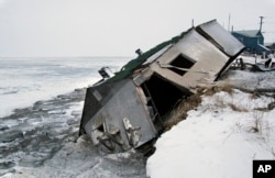 FILE - In this Dec. 8, 2006, file photo, Nathan Weyiouanna's abandoned house at the west end of Shishmaref, Alaska, sits on the beach after sliding off during a fall storm in 2005. Unofficial ballot returns from a special election held on Tuesday, Aug. 16