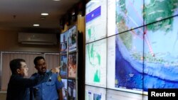 Indonesia's vice-president Jusuf Kalla (L) monitors progress in the search for AirAsia Flight QZ8501 during a visit to the National Search and Rescue Agency in Jakarta, December 28, 2014.