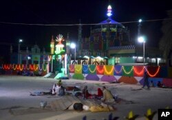 FILE - Pakistani worshippers sit outside a shrine after a bomb blast in Jhal Magsi, about 400 kilometers (240 miles) east of Quetta, Pakistan, Oct. 5, 2017.