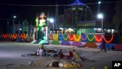 Pakistani worshippers sit outside a shrine after a bomb blast in Jhal Magsi, about 400 kilometers (240 miles) east of Quetta, Pakistan, Oct. 5, 2017. 