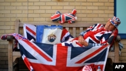 Royal supporter Terry Hutt poses for pictures on a bench where he has been camped out for 12 days outside the Lindo Wing of St Mary's Hospital in London, where Prince William and his wife Catherine's baby is expected to be born.